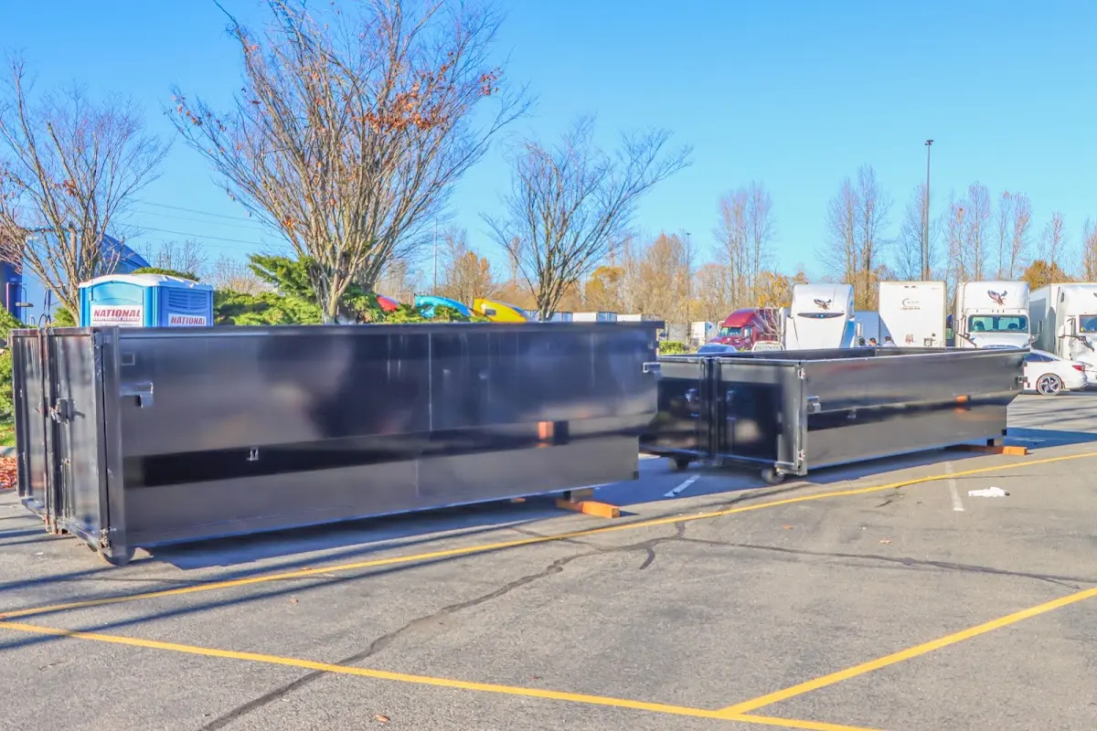 Professional dumpster rental service with roll-off container on residential driveway in Potsdam